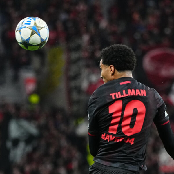 Malik Tillman heading the ball during a Bayer Leverkusen game.