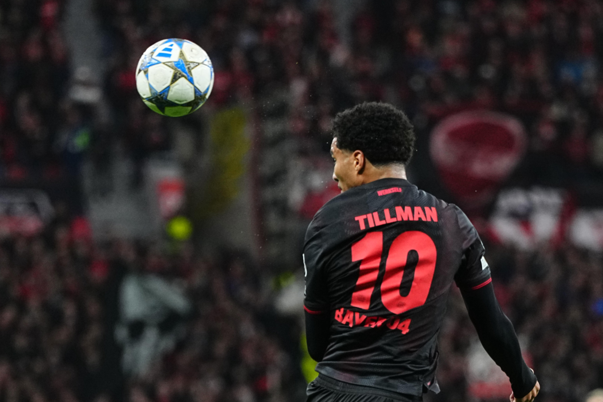 Malik Tillman heading the ball during a Bayer Leverkusen game.
